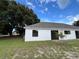 Backyard view with sliding glass doors and a tree on the side of the house at 301 Oak Track Way, Ocala, FL 34472