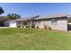 Charming single-story home featuring a well-manicured lawn and a classic brick exterior under a clear blue sky at 3853 Se 60Th St, Ocala, FL 34480