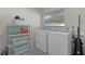 This laundry room includes a washer and dryer set with storage at 3853 Se 60Th St, Ocala, FL 34480