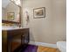 Bathroom featuring wood floors, brown vanity, framed picture, with a toilet at 3999 Sw 51St Ct, Ocala, FL 34474