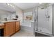 Bright bathroom featuring a glass enclosed shower, soaking tub and wooden vanity with tile flooring at 3999 Sw 51St Ct, Ocala, FL 34474