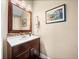 Bathroom featuring wood floors, brown vanity, framed picture, with a toilet at 3999 Sw 51St Ct, Ocala, FL 34474