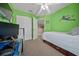 Bright bedroom with green walls, carpet flooring, ceiling fan, and desk area at 3999 Sw 51St Ct, Ocala, FL 34474