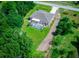 Aerial shot of a home with a screened-in pool, surrounded by greenery and a gravel driveway at 4160 Sw 98Th St, Ocala, FL 34476