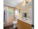 Well-lit bathroom with a shower, bathtub, and a wooden vanity at 4160 Sw 98Th St, Ocala, FL 34476