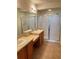 Bathroom featuring double sinks, spacious countertops, wood cabinets, and a glass-enclosed shower at 4525 Sw 52Nd Cir # 105, Ocala, FL 34474