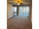 Living room with ceiling fan, carpeted floors, and sliding door to backyard at 4525 Sw 52Nd Cir # 105, Ocala, FL 34474