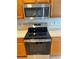 Stainless steel GE range and microwave, with oak cabinets and light countertops at 4525 Sw 52Nd Cir # 105, Ocala, FL 34474