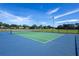 Well-maintained tennis court featuring green playing surface with blue surroundings and tall lighting at 4555 Sw 52Nd Cir # 103, Ocala, FL 34474