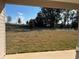 Serene backyard view showcasing a well-manicured lawn and lush greenery from covered patio at 4724 Nw 11Th St, Ocala, FL 34482