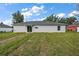 Exterior of home with a backyard, a sliding glass door, and a manicured lawn at 540 Nw 64Th Pl, Ocala, FL 34475