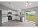 Well-lit kitchen features white cabinets, stainless appliances, granite countertops, and sliding glass door at 540 Nw 64Th Pl, Ocala, FL 34475