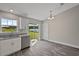 Well-lit kitchen with stainless steel dishwasher, white cabinets, and sliding glass door access to the yard at 540 Nw 64Th Pl, Ocala, FL 34475