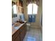 Well-maintained bathroom with a marble countertop vanity and tiled flooring at 5500 Nw 23Rd Pl, Ocala, FL 34482