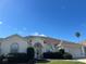 Charming single-story home featuring an arched entryway, attached garage, and manicured landscaping under a clear blue sky at 5500 Nw 23Rd Pl, Ocala, FL 34482