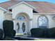 Elegant front entrance featuring a double door and arched window, flanked by well-maintained landscaping at 5500 Nw 23Rd Pl, Ocala, FL 34482