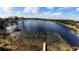 Panoramic aerial view of a scenic lake with a wooden dock and lush greenery on the shoreline at 5526 Se 170Th Ct, Ocklawaha, FL 32179