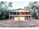 Exterior view of elevated home featuring a screened porch and painted facade at 5526 Se 170Th Ct, Ocklawaha, FL 32179