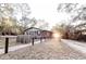 Exterior view of cabin-style home with fenced yard and sunlit clearing at 5526 Se 170Th Ct, Ocklawaha, FL 32179