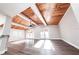 Open living area with wood-look floors and wood-accent ceiling beams, flooded with natural light at 5526 Se 170Th Ct, Ocklawaha, FL 32179