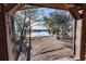 Picturesque view of the serene lake framed by trees and vegetation, seen through the wooden framed window at 5526 Se 170Th Ct, Ocklawaha, FL 32179