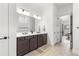 Bright bathroom with a double sink vanity, decorative mirrors, and wood-look tile flooring at 5728 Sw 90Th Court Rd, Ocala, FL 34481