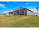 Exterior showcasing screened patio and an outdoor living area with seating in a well-manicured backyard at 5728 Sw 90Th Court Rd, Ocala, FL 34481