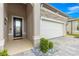 Close up of front entrance showing decorative glass front door, stone accents and manicured landscaping at 5728 Sw 90Th Court Rd, Ocala, FL 34481