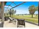 Relaxing screened lanai with comfortable seating, perfect for enjoying serene lake and golf course views at 5728 Sw 90Th Court Rd, Ocala, FL 34481