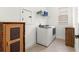 A well-organized laundry room with a washer, dryer, shelving, and wood accents at 5728 Sw 90Th Court Rd, Ocala, FL 34481