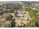 Aerial view of the residence, a pool and an outbuilding surrounded by a lush forest at 5995 Se 22Nd Ave, Ocala, FL 34480