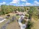 Aerial view of home with a long driveway, wooden fencing, and an expansive lawn at 5995 Se 22Nd Ave, Ocala, FL 34480