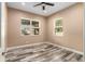 Bedroom with hardwood floors, ceiling fan and natural light from two large windows at 5995 Se 22Nd Ave, Ocala, FL 34480