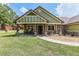 Charming home featuring a cozy front porch with rocking chairs and stone-accented columns at 5995 Se 22Nd Ave, Ocala, FL 34480