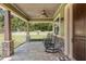 Inviting covered porch with stone pillars, ceiling fans, and ample space for relaxing seating at 5995 Se 22Nd Ave, Ocala, FL 34480