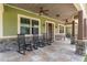 Inviting front porch with tiled flooring, stone pillars, and traditional rocking chairs at 5995 Se 22Nd Ave, Ocala, FL 34480