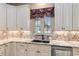 A well-lit kitchen sink area features granite countertops and a window with backyard view at 5995 Se 22Nd Ave, Ocala, FL 34480