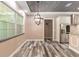 Bright living room with a chandelier and wood-look floors, leading to a stylish kitchen at 5995 Se 22Nd Ave, Ocala, FL 34480