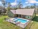 Back of green home featuring an in-ground pool with brick pavers and a metal fence at 5995 Se 22Nd Ave, Ocala, FL 34480