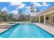 A backyard pool with a spa and a covered patio in a fenced yard at 5995 Se 22Nd Ave, Ocala, FL 34480