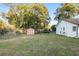 View of the backyard with mature trees and a storage shed at 711 Se 26Th St, Ocala, FL 34471