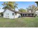 Home's backyard featuring a brick patio, grass, and established landscaping at 711 Se 26Th St, Ocala, FL 34471