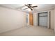 Bright bedroom featuring neutral carpet, ceiling fan, and closet space at 711 Se 26Th St, Ocala, FL 34471