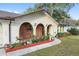 Arched entryway with brick accents, mature landscaping, and a curved walkway creates an inviting entrance at 711 Se 26Th St, Ocala, FL 34471