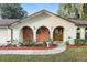 Arched entry with stylish front door, brick accents, and manicured landscaping provides welcoming curb appeal at 711 Se 26Th St, Ocala, FL 34471