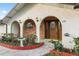 Close-up of the home's inviting arched entryway framed by brick accents and greenery at 711 Se 26Th St, Ocala, FL 34471