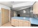 A kitchen featuring blonde wood cabinets, blue countertops, and a view into the living room at 711 Se 26Th St, Ocala, FL 34471