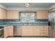 A kitchen featuring stainless steel appliances, blonde wood cabinets, and blue countertops at 711 Se 26Th St, Ocala, FL 34471