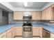 A kitchen featuring stainless steel appliances, blonde wood cabinets, and blue countertops at 711 Se 26Th St, Ocala, FL 34471