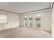 Bright living room featuring neutral carpeting and an array of sunlit windows at 711 Se 26Th St, Ocala, FL 34471